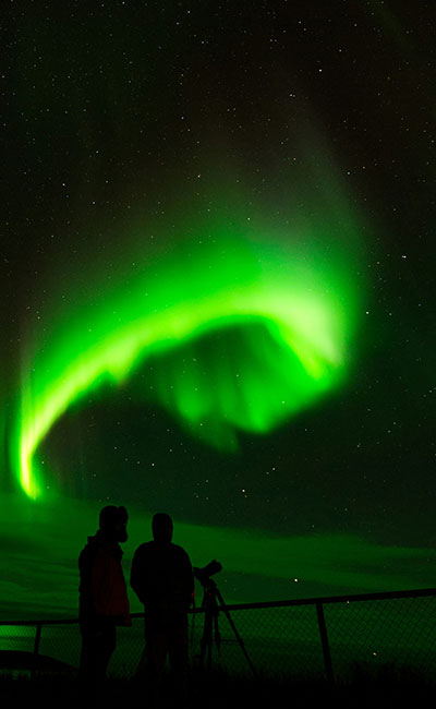 personas viendo auroras boreales en Islandia